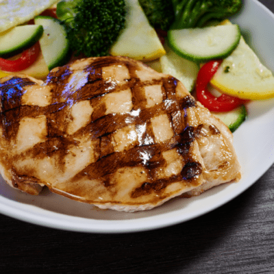 grilled chicken breast for kids with a side of veggies placed on a plate